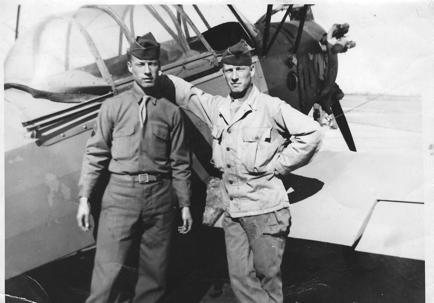 Bob and Dick, identical twin brothers, before a training aircraft